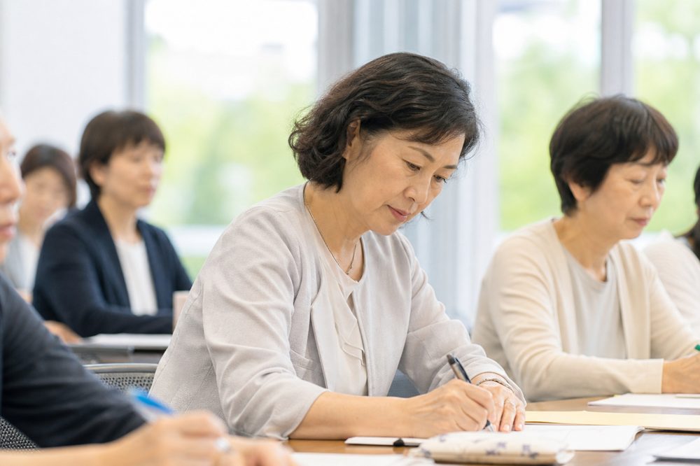 埼玉のセミナー会場でノートを取る50代女性