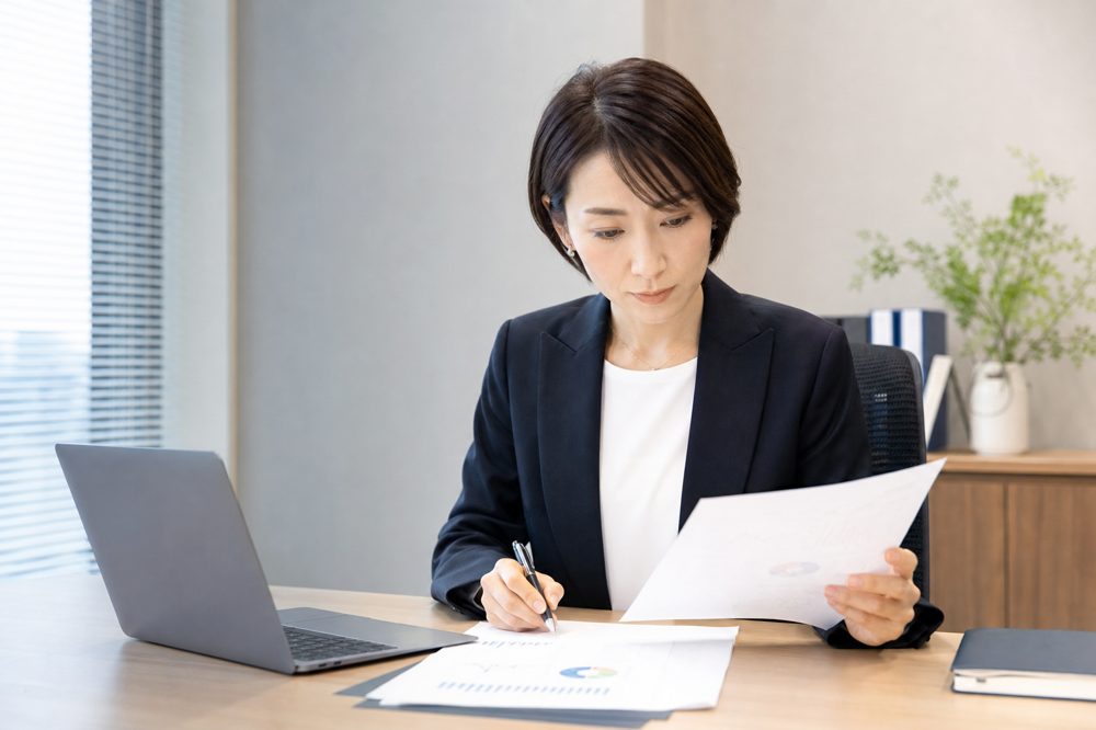 特定技能の契約書類を確認している日本人採用担当者