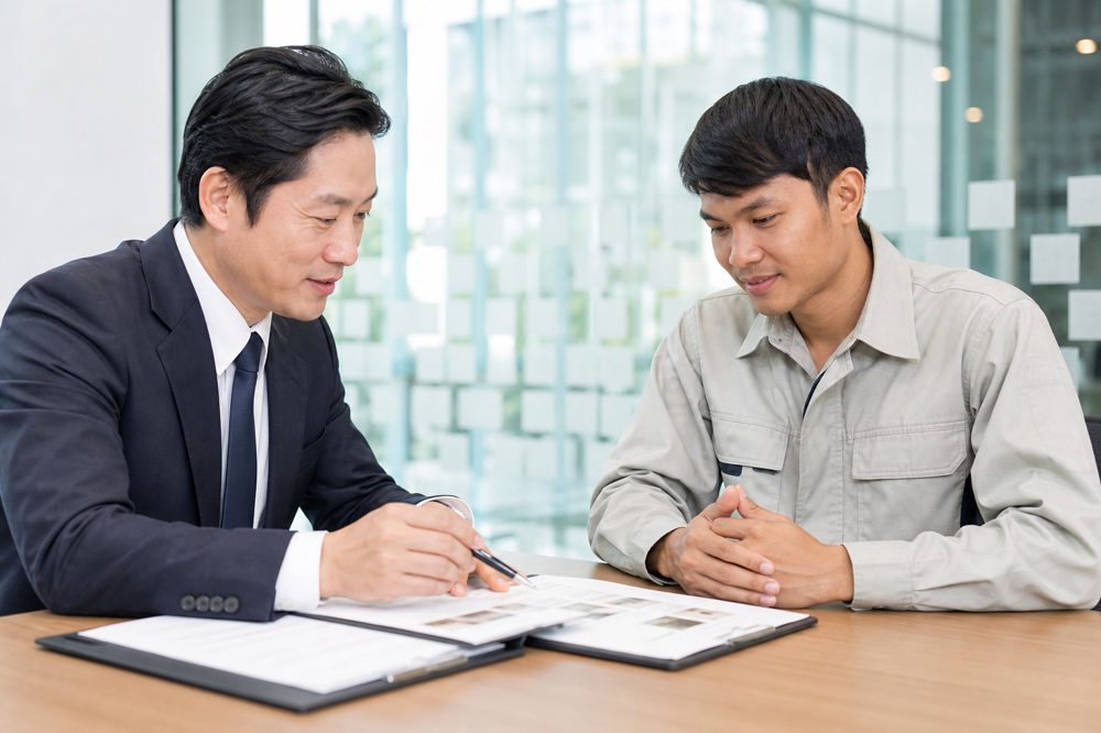 日本人担当者とベトナム人建設労働者がキャリア資料を確認する面談場面
