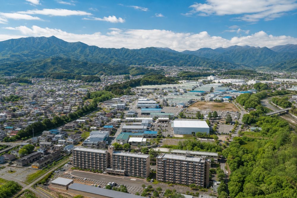 群馬県の住宅・工業エリアを上空から望む収益物件のイメージ
