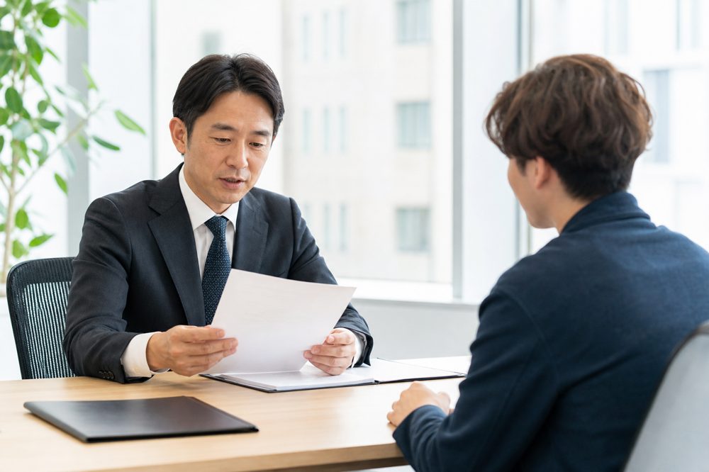 採用担当者が外国人留学生の在留資格書類を確認している様子
