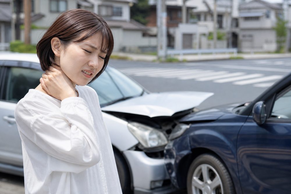 愛知県の道路で交通事故後に首を押さえる人物
