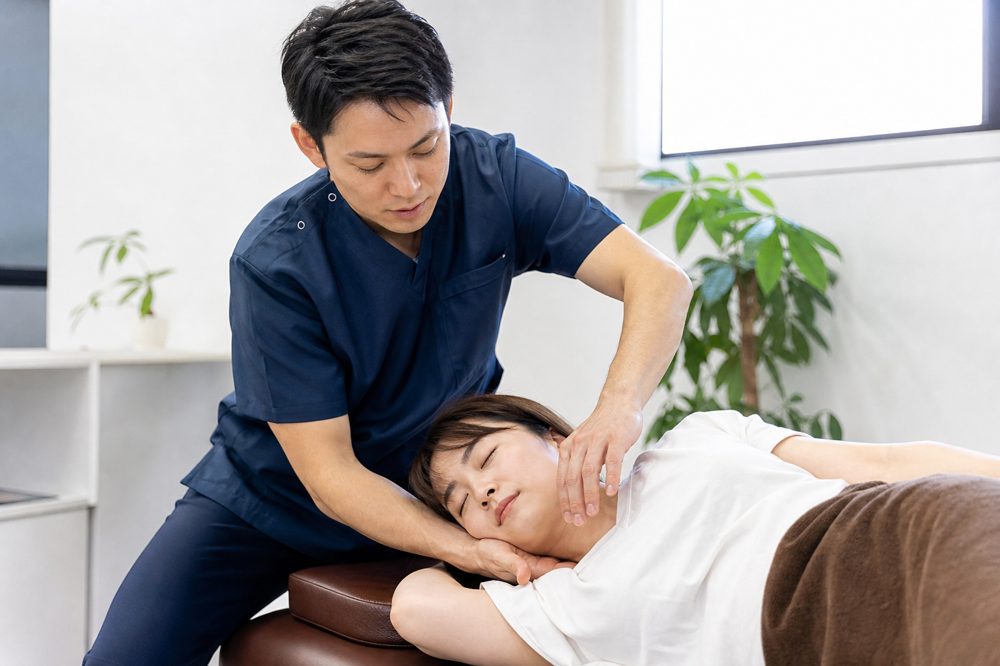 整骨院で施術者が患者の首と肩を手技で治療している様子