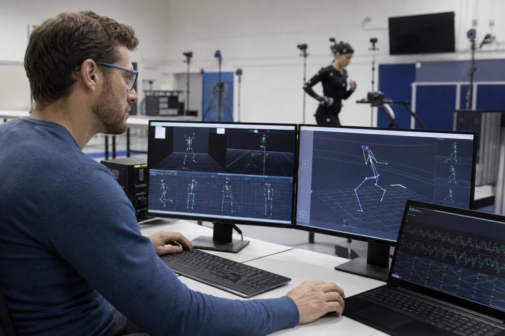 大学のスポーツ科学ラボでモーションキャプチャデータを解析する研究者