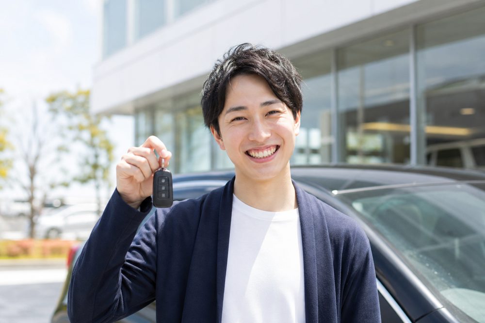 車を高く売るイメージ・笑顔でカーキーを持つ人物