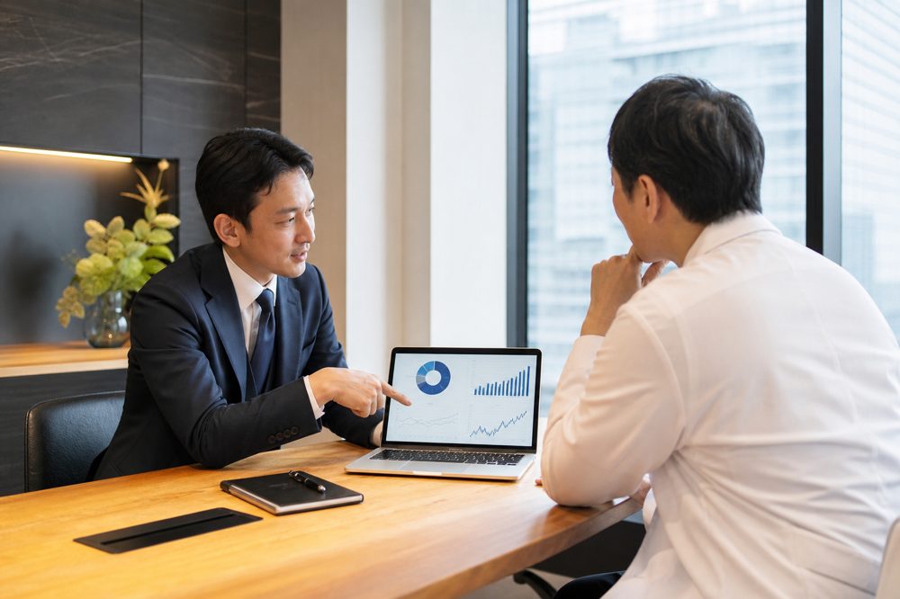 ファイナンシャルアドバイザーが医師に投資プランを説明しているシーン