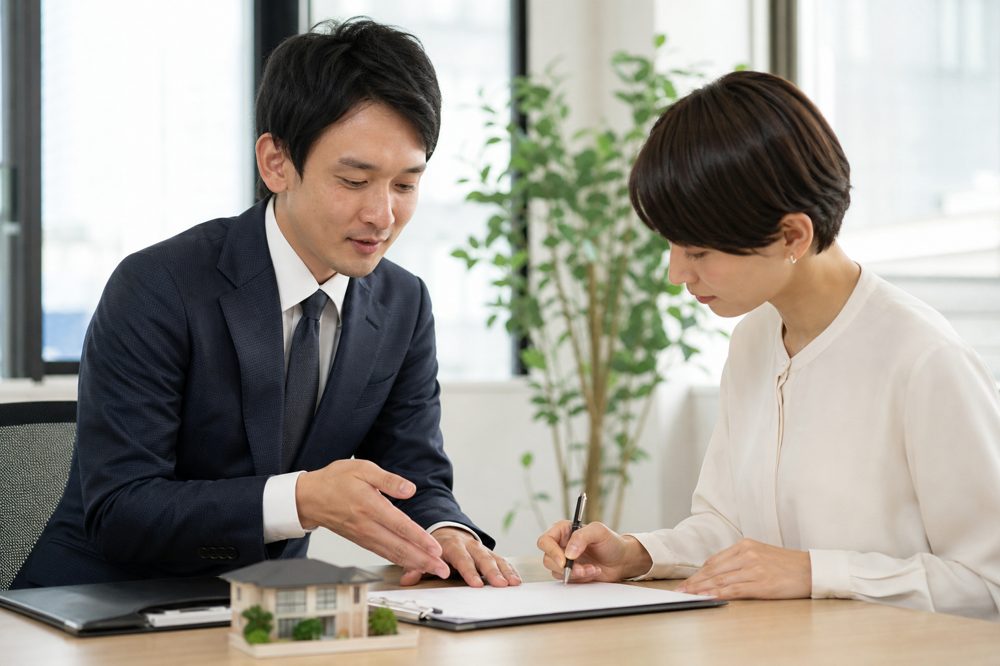 不動産会社で売買契約書にサインする売主のイメージ