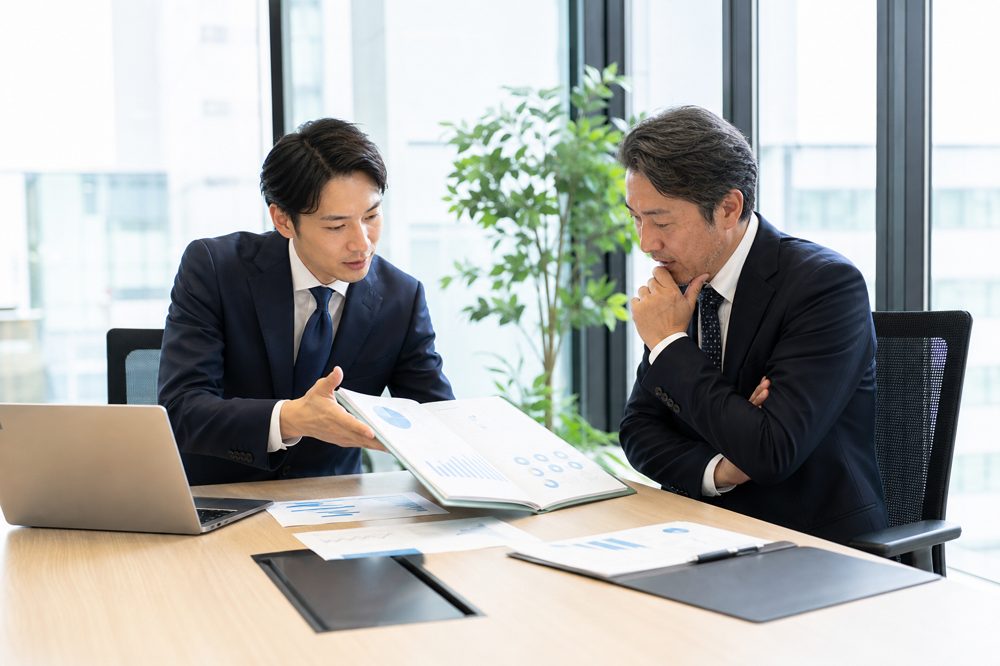 フランチャイズ加盟説明会でオーナー候補と担当者が契約内容を確認している様子
