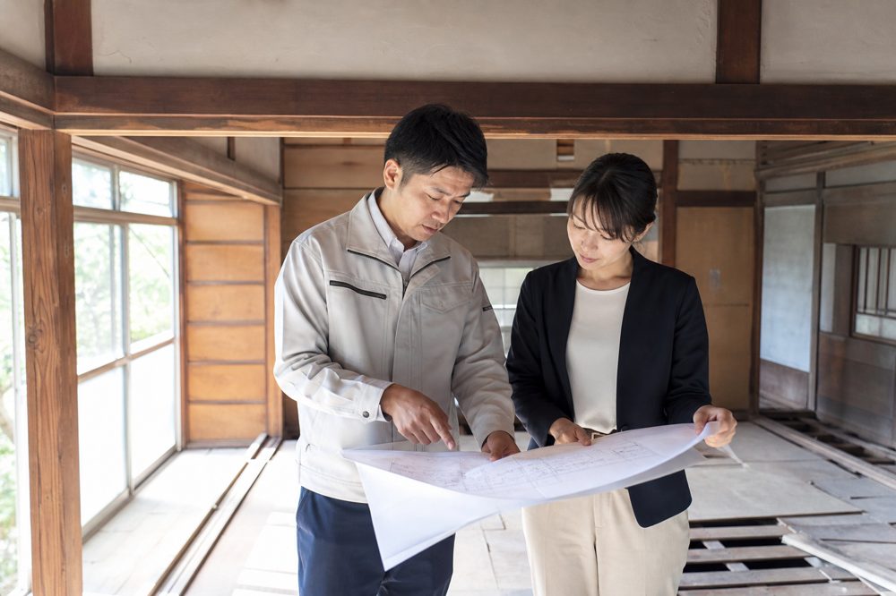空き家のリノベーション計画を現地で確認している施工業者と設計士