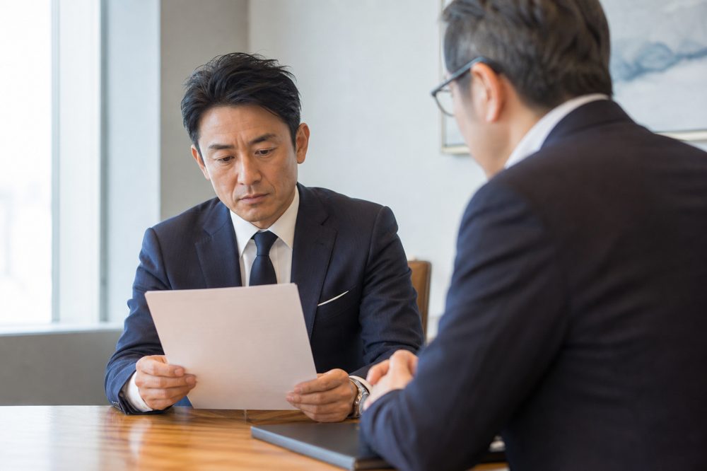 フランチャイズ契約書を弁護士と確認しているオーナーのシーン
