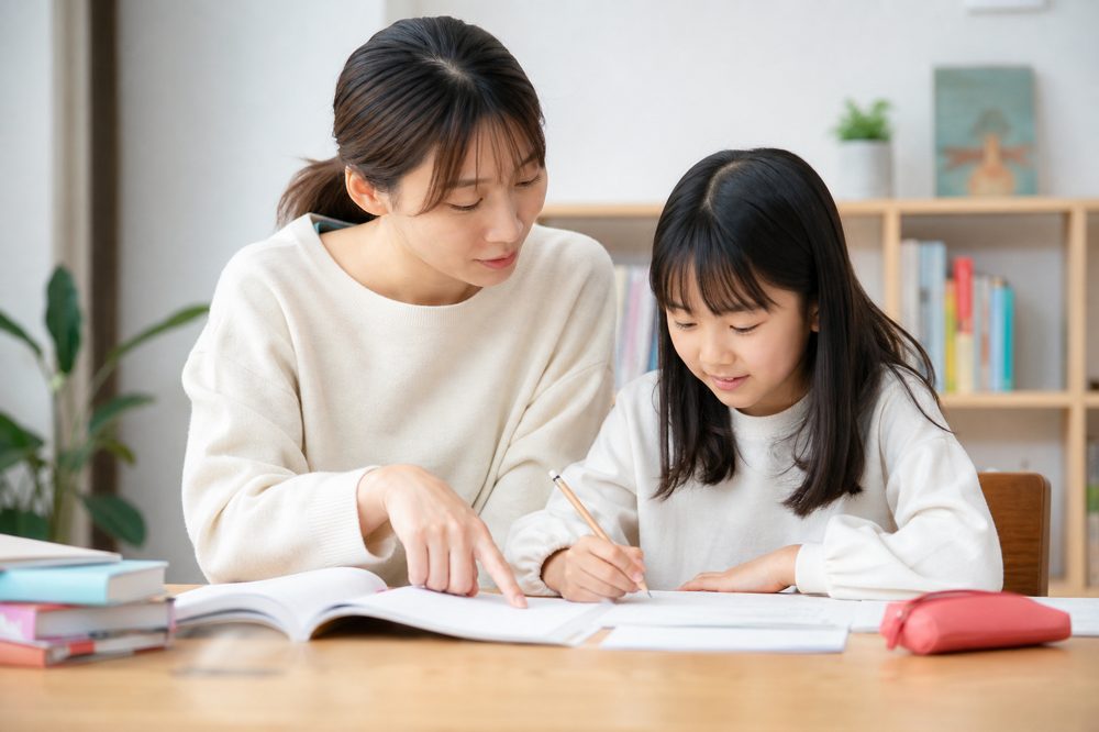 保護者と小学生が一緒に塾の資料を確認している様子