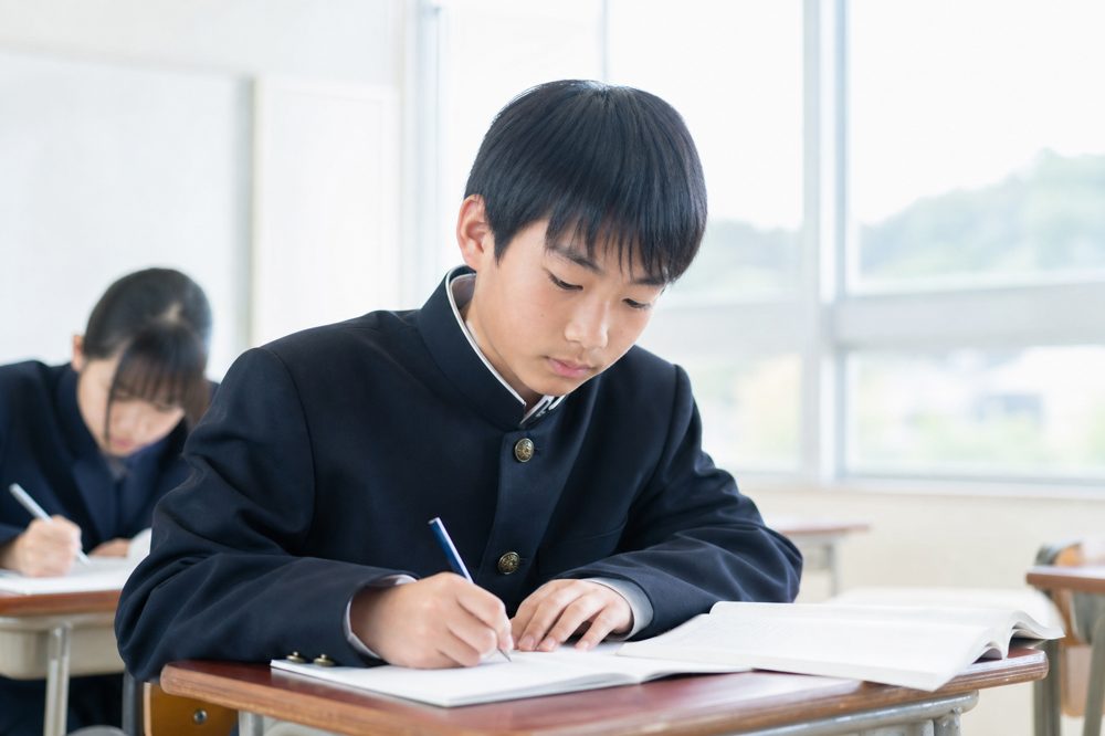 岡山の明るい教室で真剣に勉強する中学生