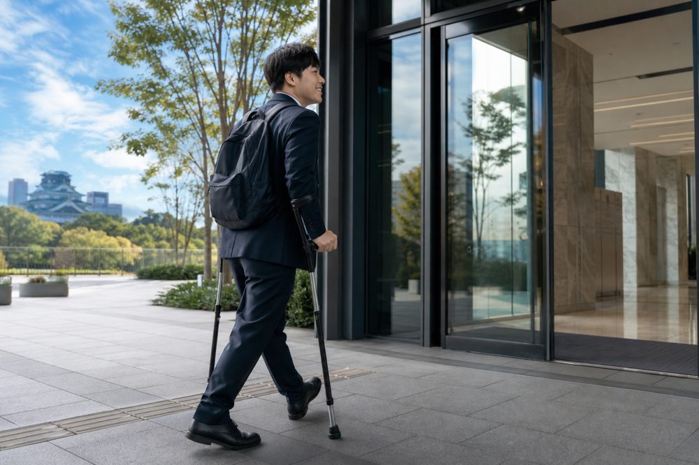 熊本の企業に就職する障がい者が自信を持ってビルに入る様子