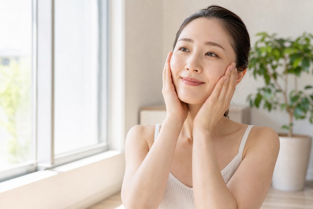 美容鍼の効果を高める朝のセルフケア・顔のストレッチをする女性