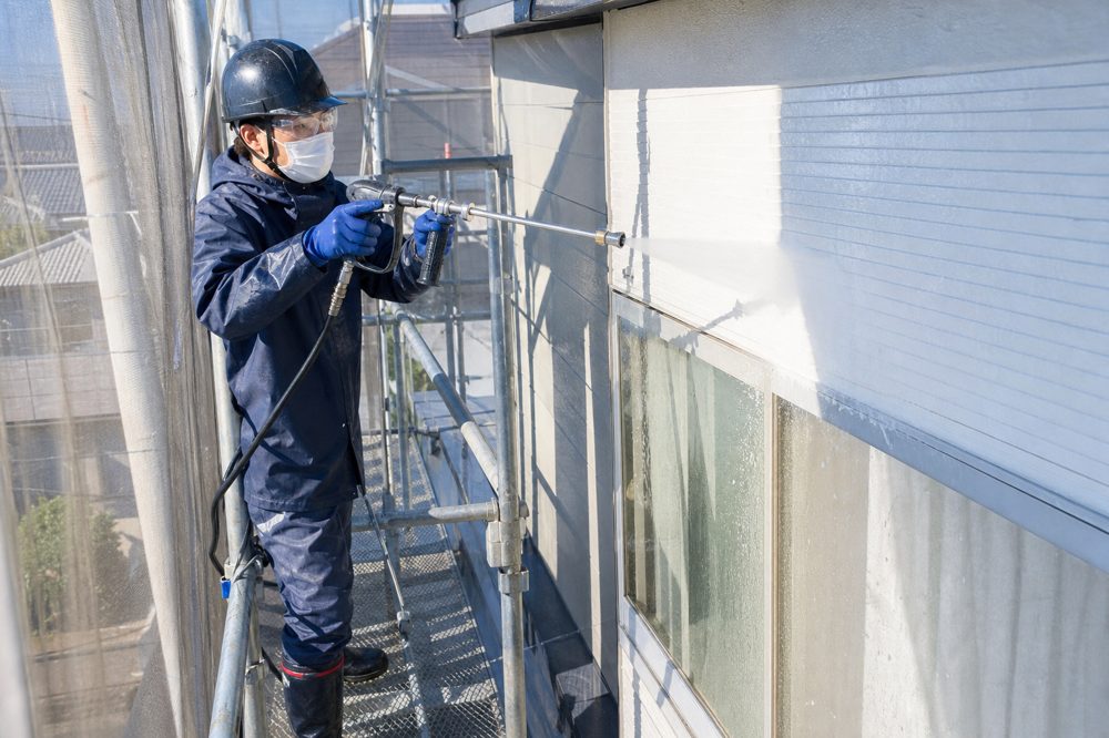 高圧洗浄機を使う外壁洗浄の作業員