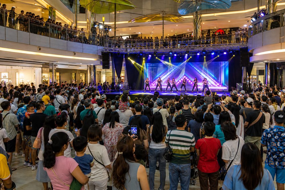 ショッピングモールのイベントスペースでライブパフォーマンスに群がる大勢の観客