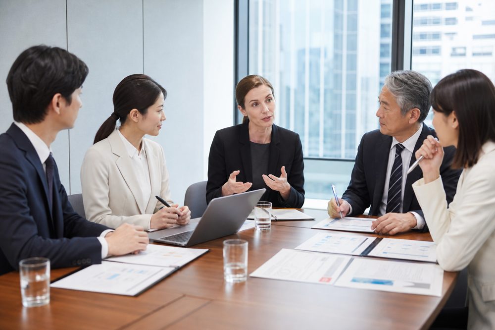 育成就労制度への移行について会議室で資料を確認する企業担当者と通訳者