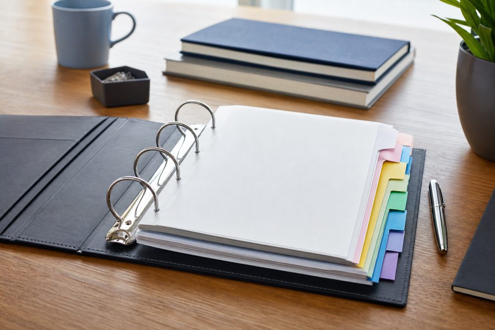 色分けされたファイルに整理された書類が机の上に並んでいる様子