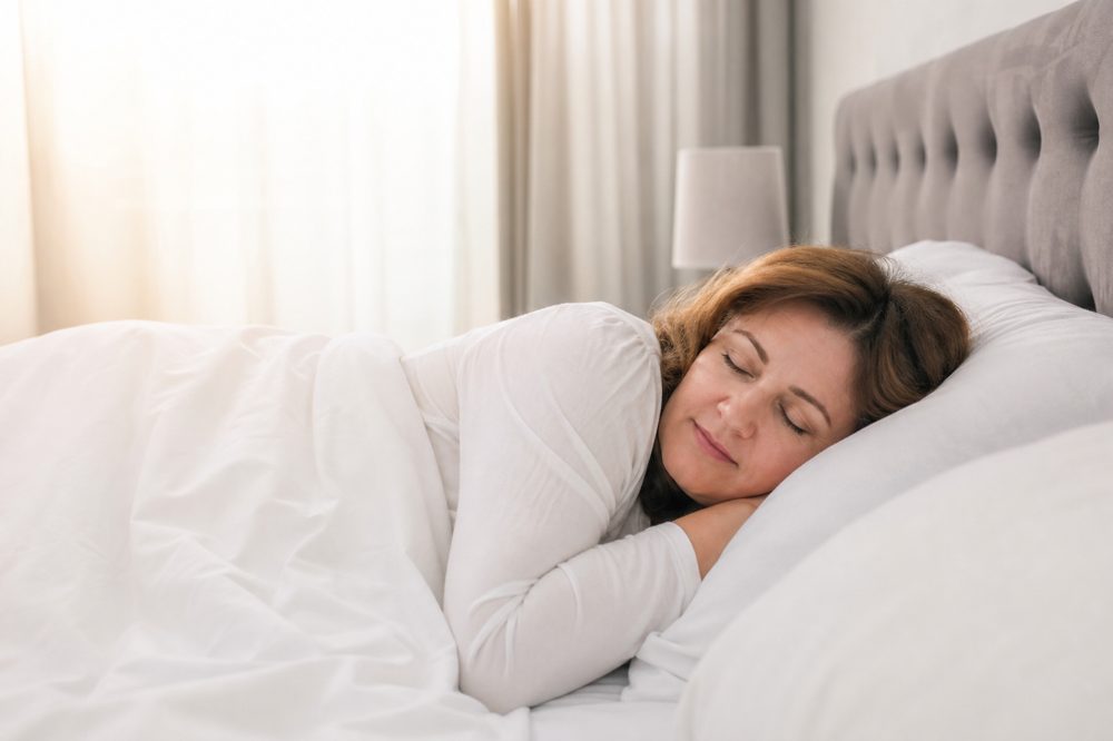 40代・50代女性が穏やかに快眠している朝の寝室