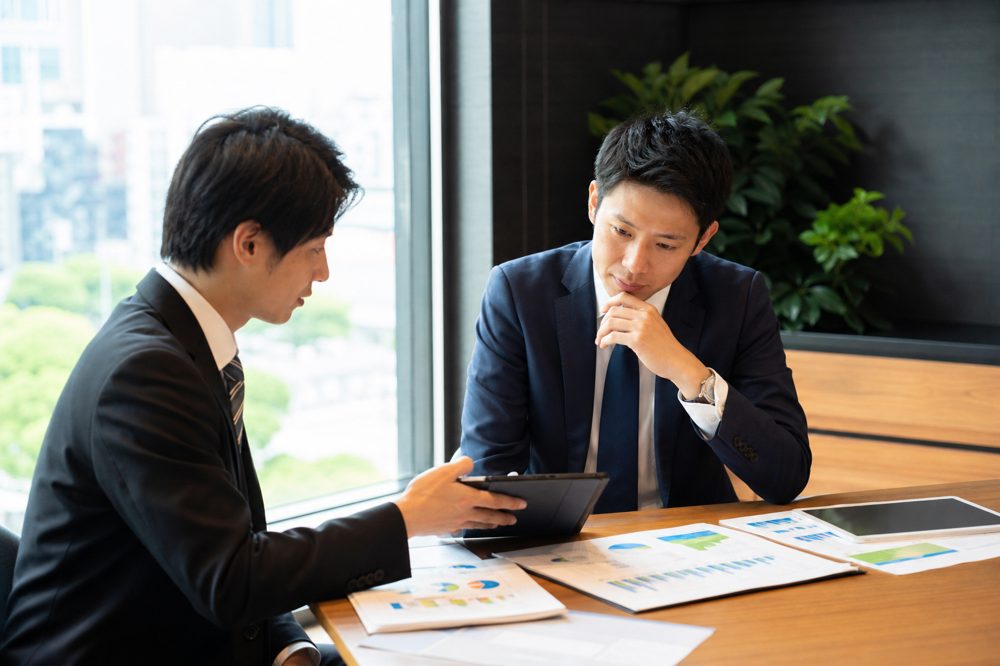 複数のFPが保険プランを比較しているオフィスシーンのイメージ