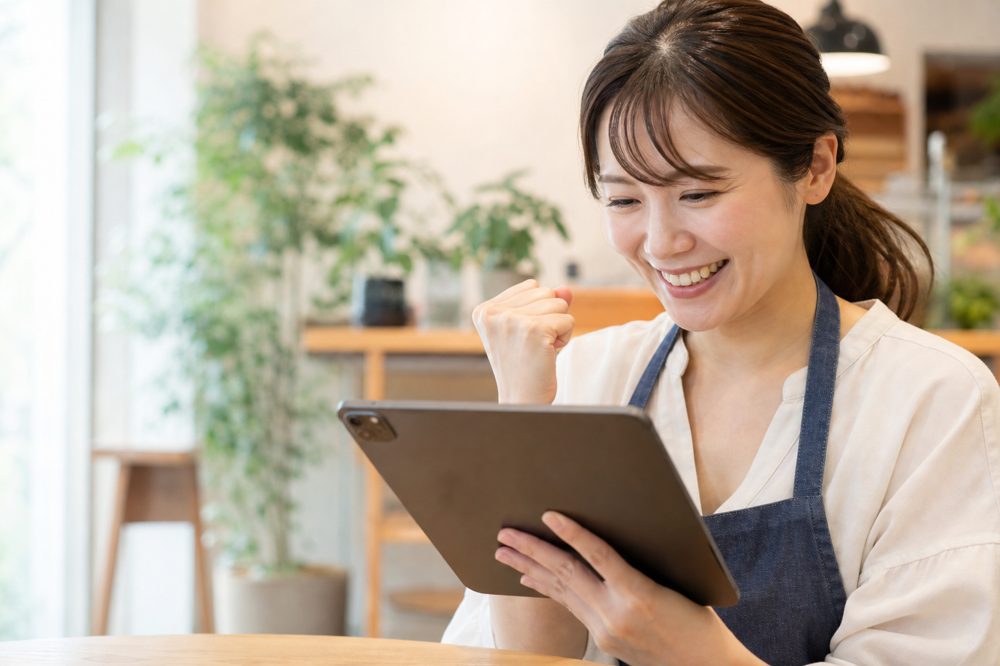 SNS採用キャンペーン成功後に応募数の改善をタブレットで確認する千葉市の中小企業経営者