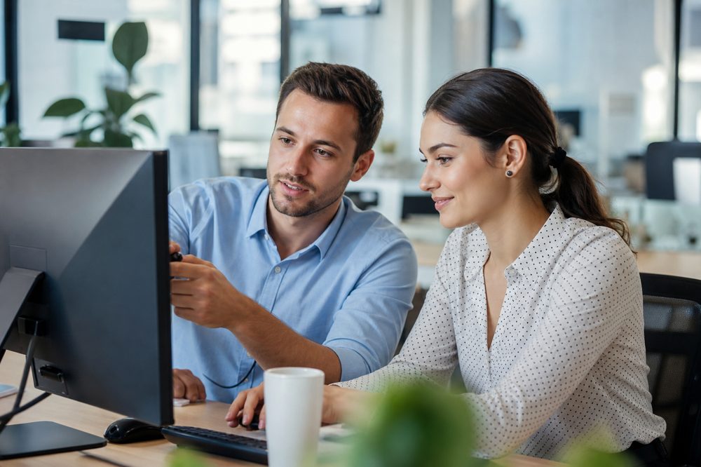 バディ制でベテラン社員が若手社員に業務を教えている様子