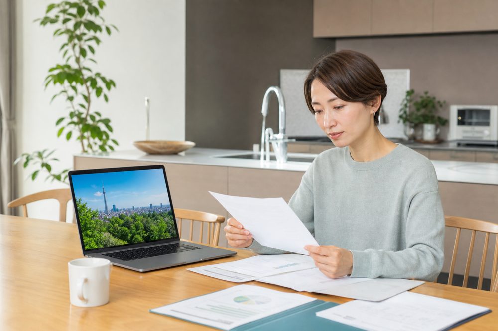 自宅で蓄電池補助金の申請書類を確認している東京都民の様子