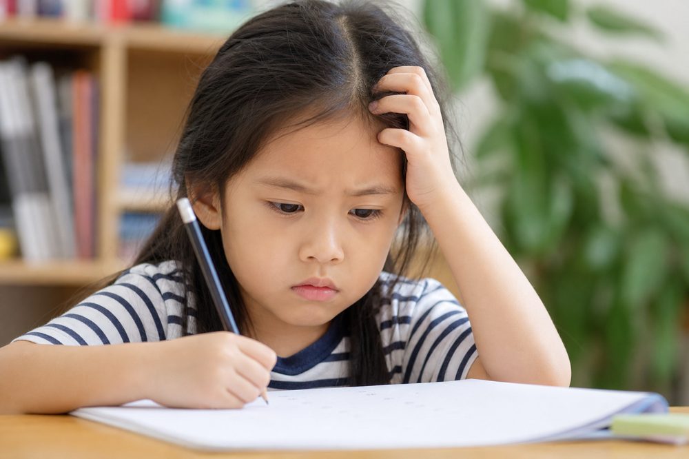 勉強に苦手意識を持つ子どもが問題を前に悩んでいる様子