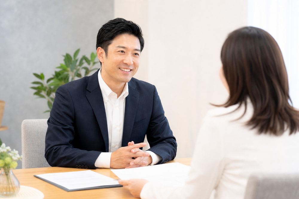 東京の結婚相談所で女性カウンセラーと笑顔で相談する男性