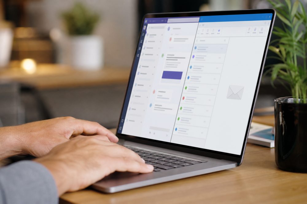 Microsoft 365のTeamsとOutlookを操作するビジネスパーソンのイメージ