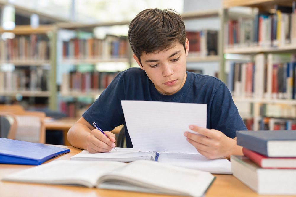 塾の自習室で集中して勉強する中学生