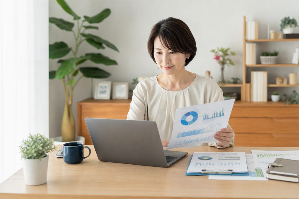 自宅でiDeCoやNISAの運用内容を確認する40代日本人女性のイメージ