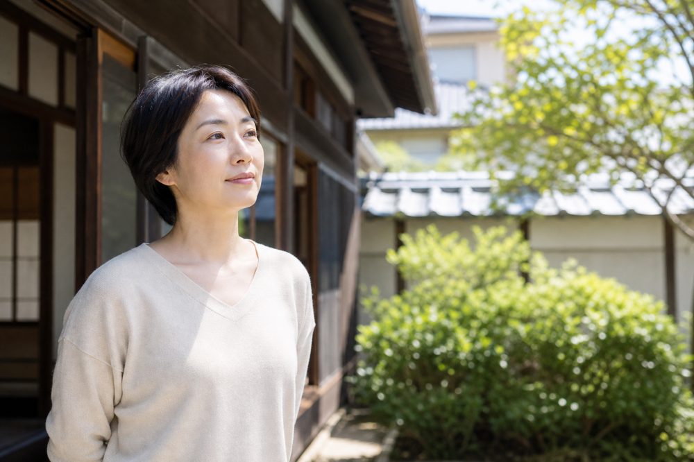 実家を相続した女性が自宅を見つめている