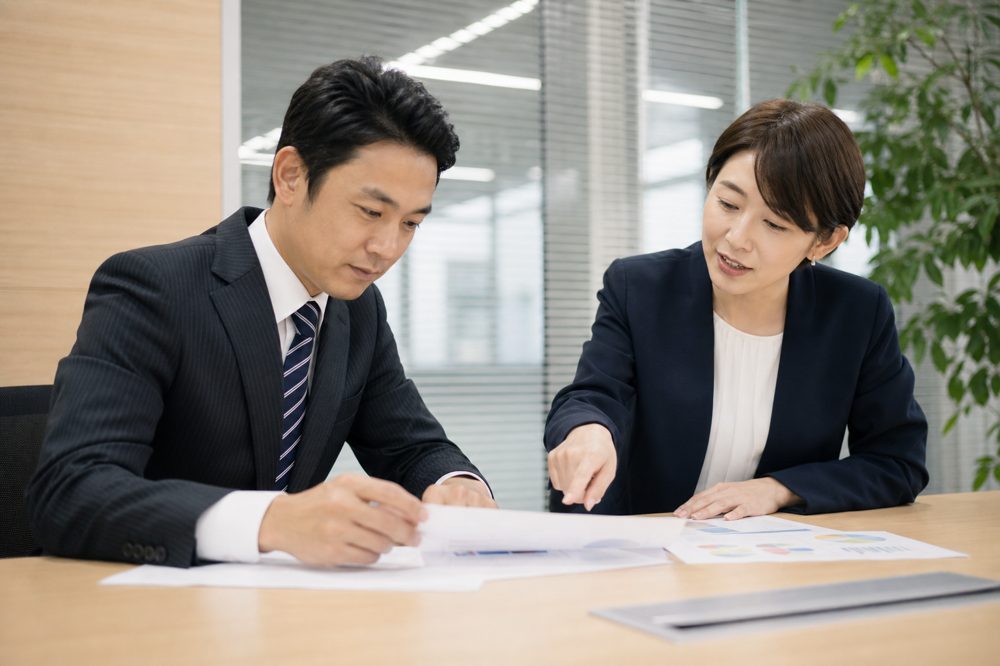会議室で登録支援機関と委託契約の内容を確認している企業担当者