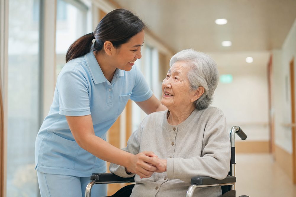 九州の介護施設でフィリピン人介護スタッフが高齢者を笑顔でサポートしている様子