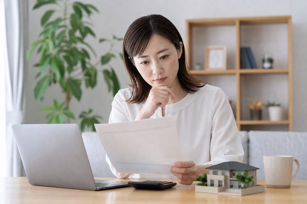 火災保険の書類を確認する日本人女性の様子