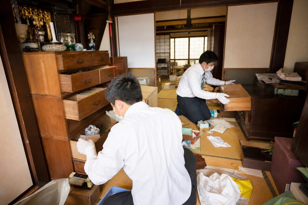 貴重品を探して引き出しや棚を確認している空き家の室内