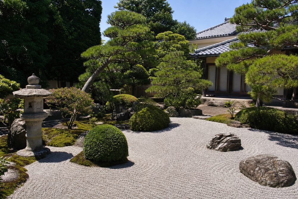 整然と手入れされた日本式庭園の庭木と石灯籠