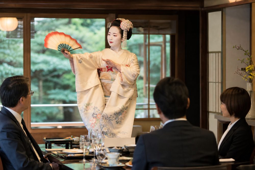 京都の料亭で舞妓が舞を披露する社員旅行の昼食シーン