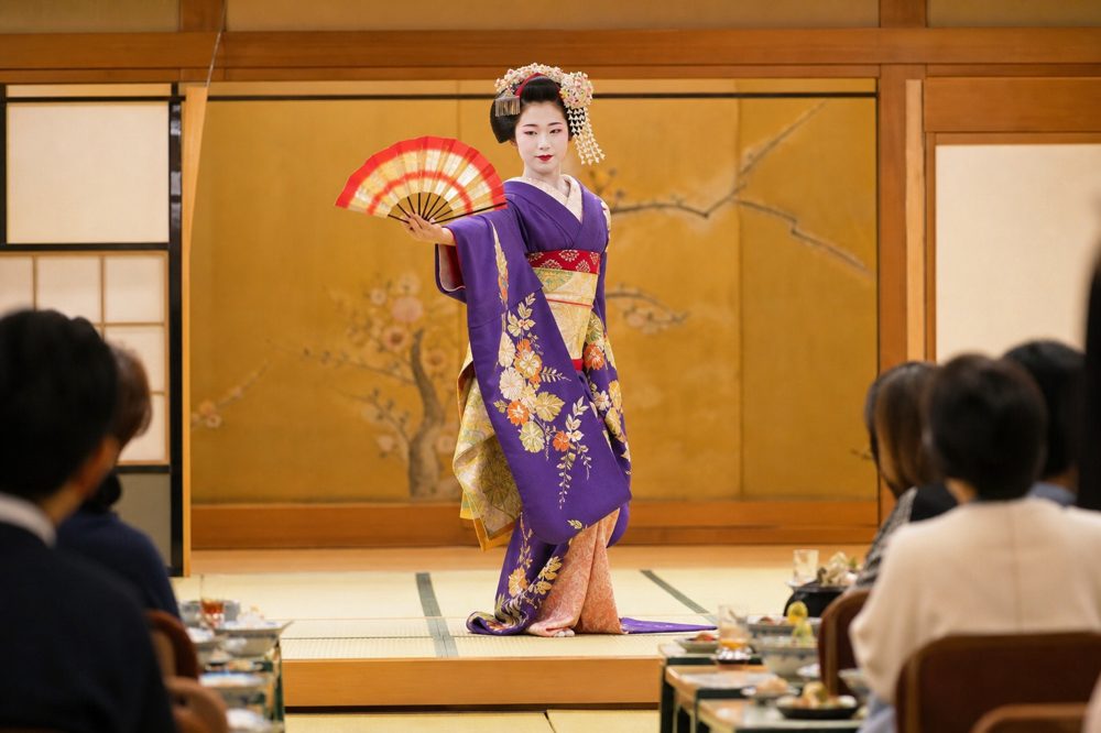 畳の舞台で扇を使い優雅に舞う舞妓のパフォーマンス