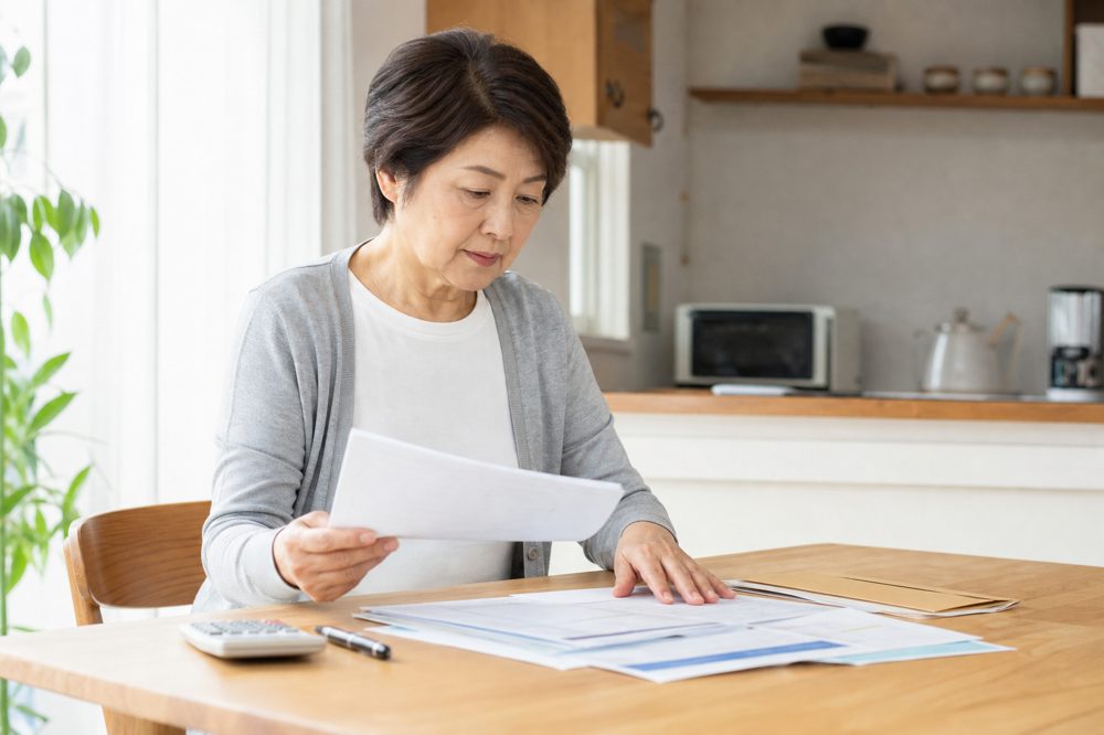 60代女性が相談前に年金書類や家計資料を整理している様子